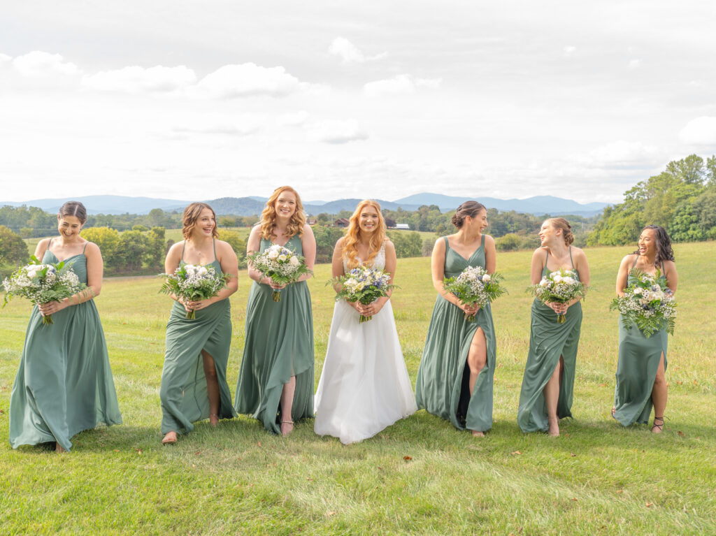 The bride and her bridesmaids walking and smiling.