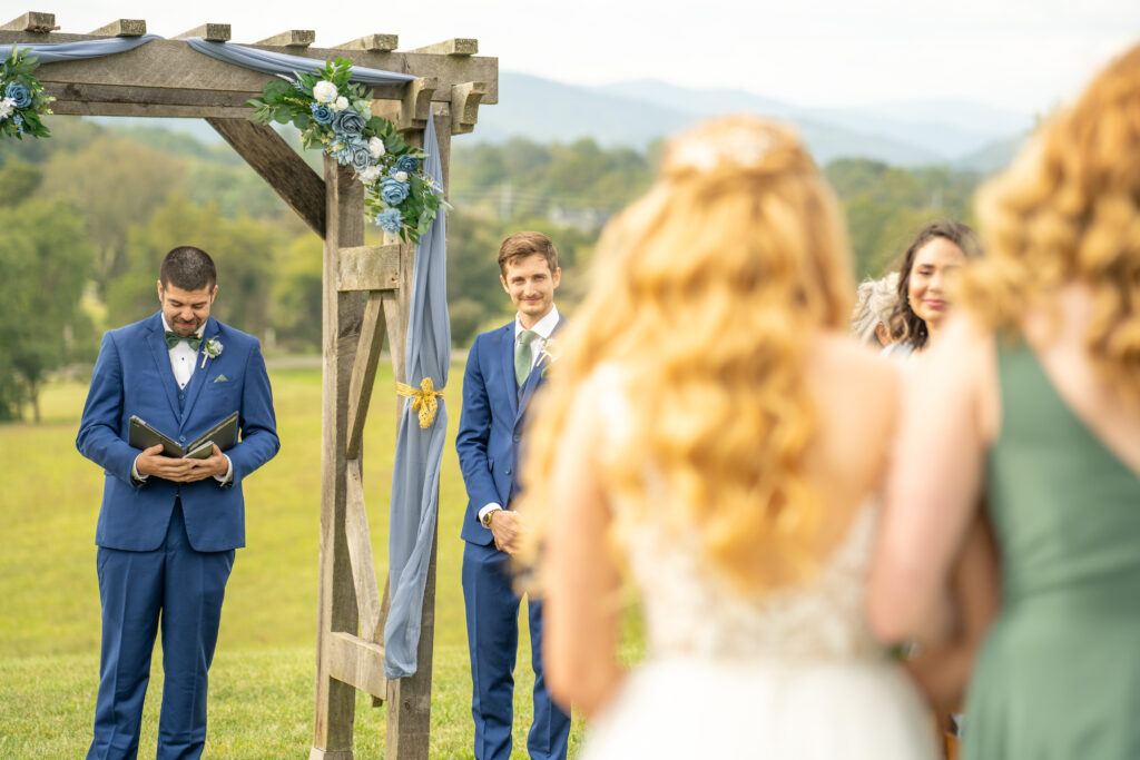 Groom smiling at the bride when she walks down the wedding isle.