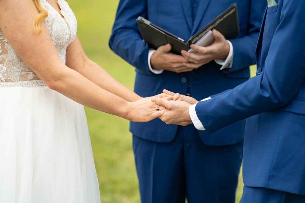 Bride and groom holding hands at the wedding alter at Renback barn.