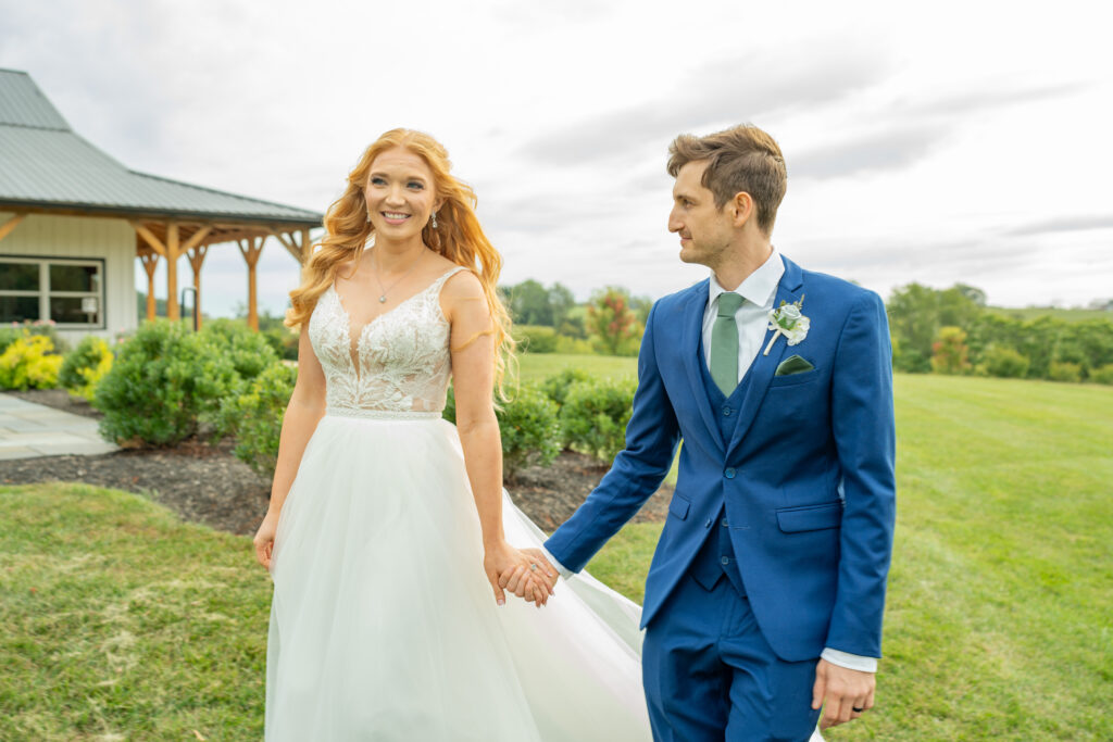 Bride and groom smiling on their wedding day with the barn of renback in the background.