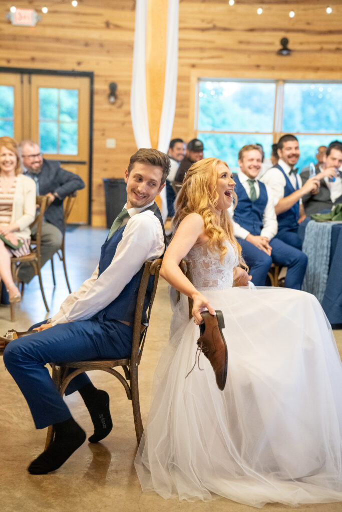 Bride and groom laugh while playing the shoe game on their wedding day.