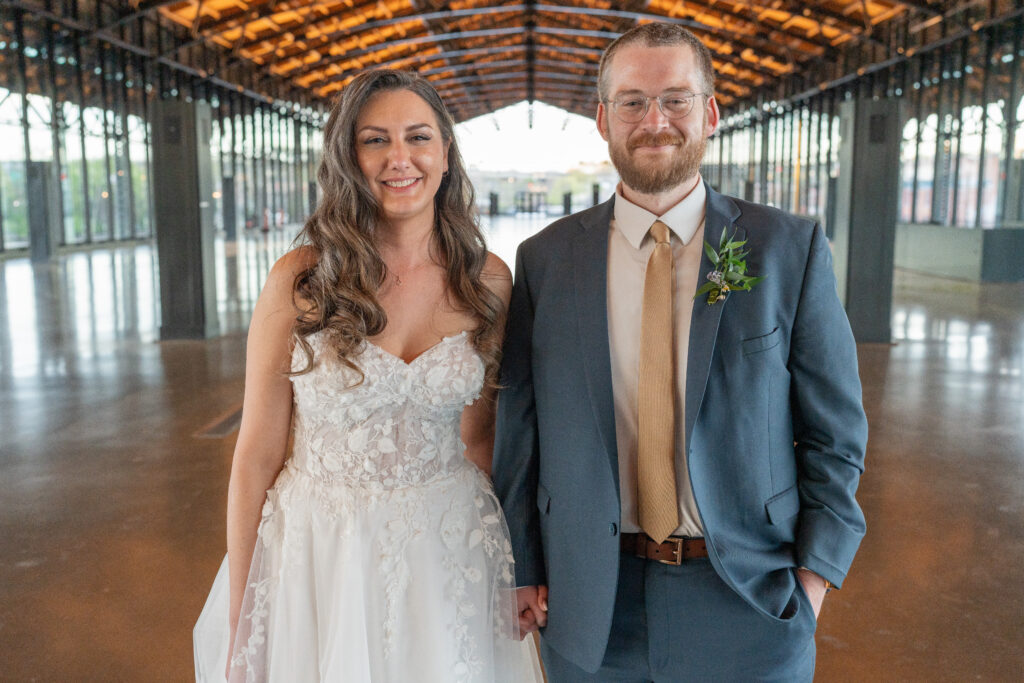 A bride and groom pose for coulees portrait with the Main Street Station as their background