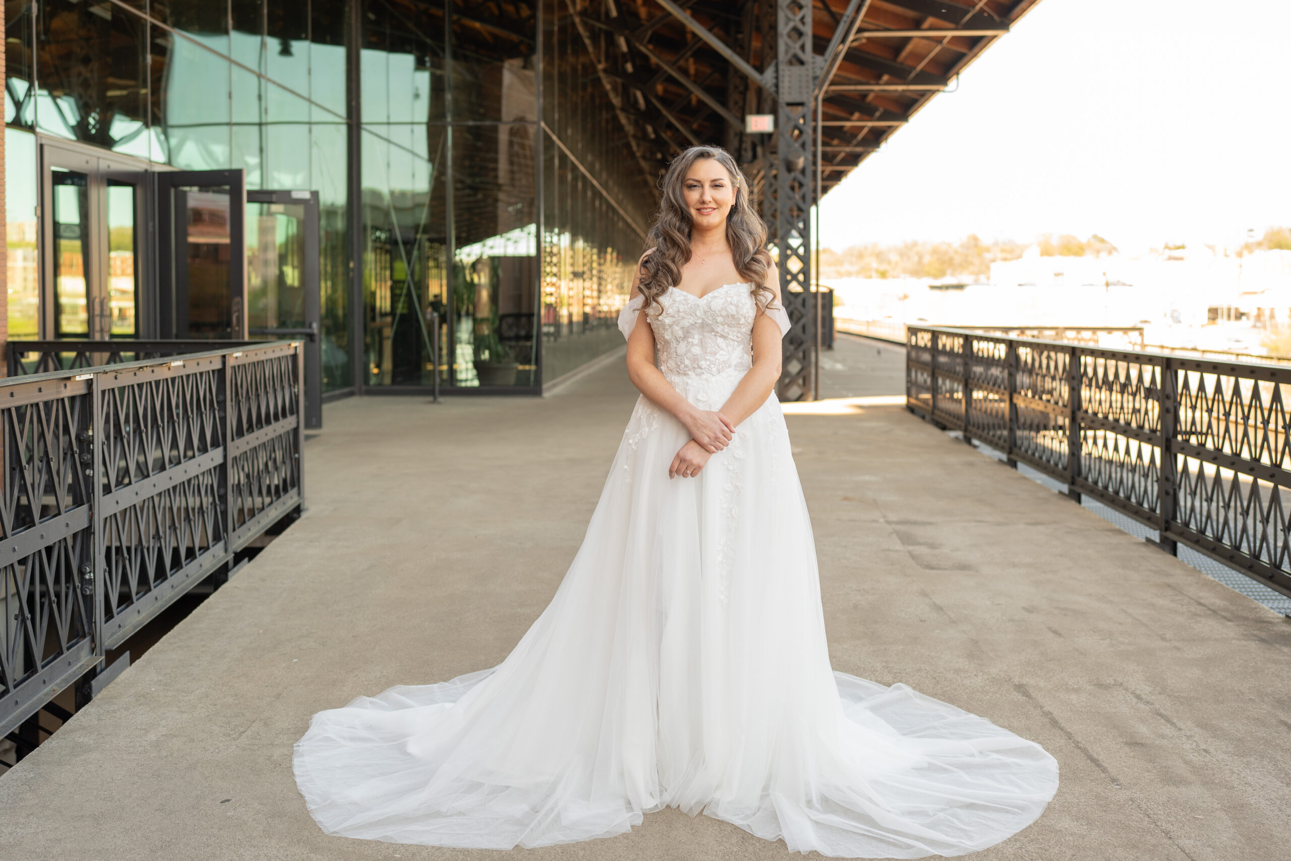 A bride at Main Street Station in Richmond, Virginia posing for bridal portraits with the city of Richmond and the train tracks in the background.