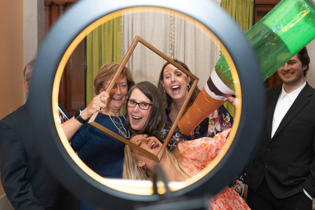 Wedding guest using a photobooth with fun props