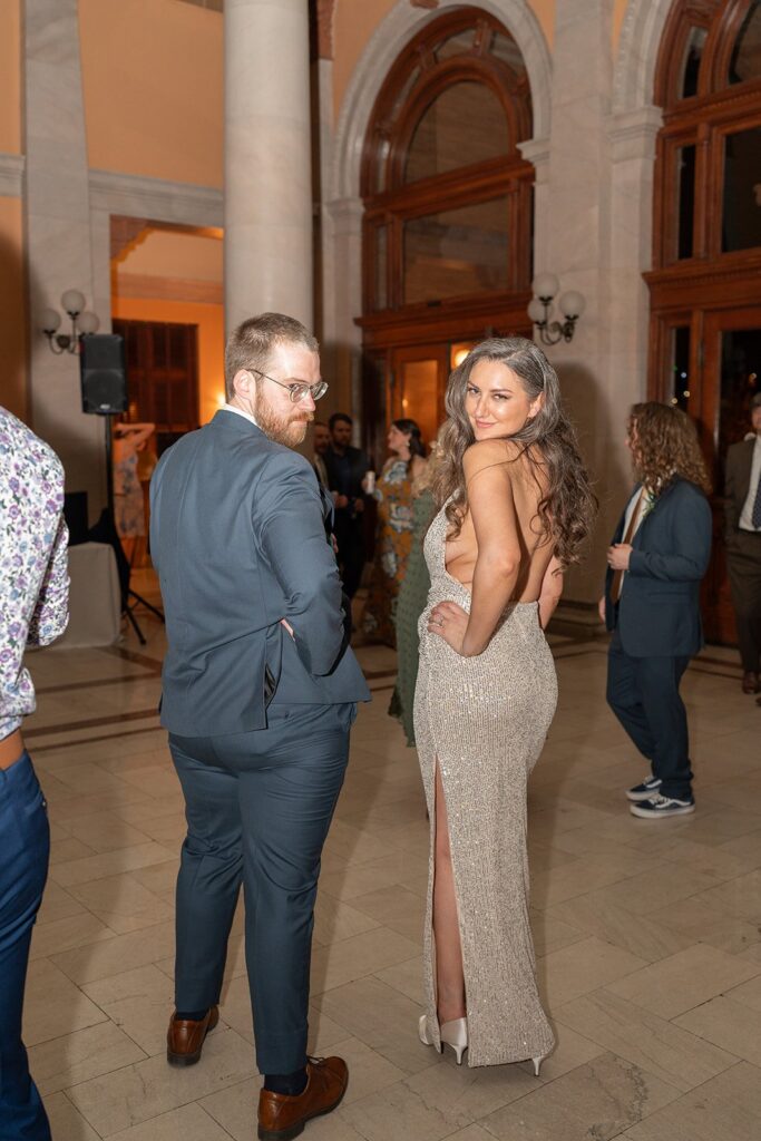 A bride and groom posing on the dance floor while others dance around them.