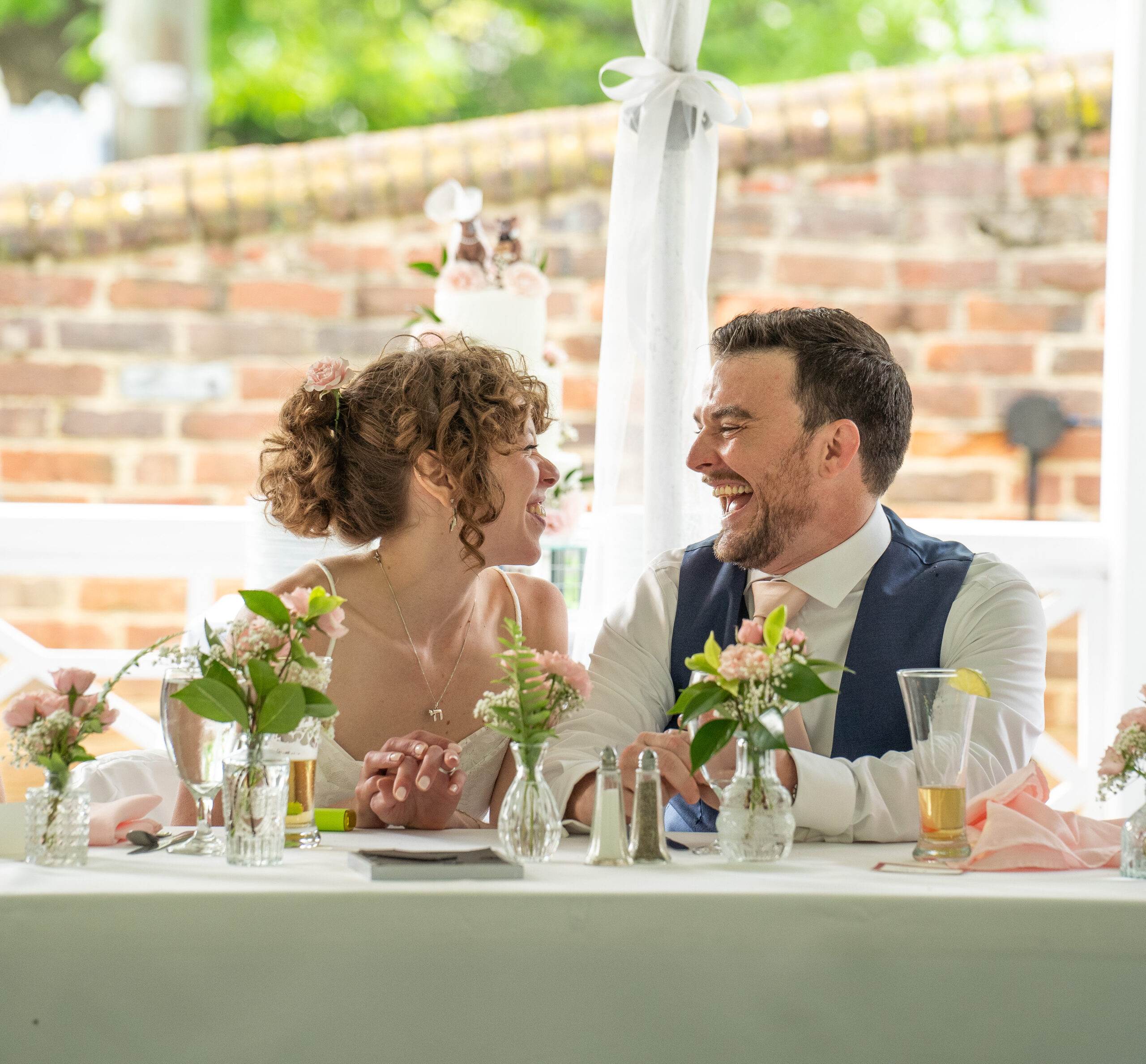 wedding couple smiling at each other during their wedding dinner in Virginia.