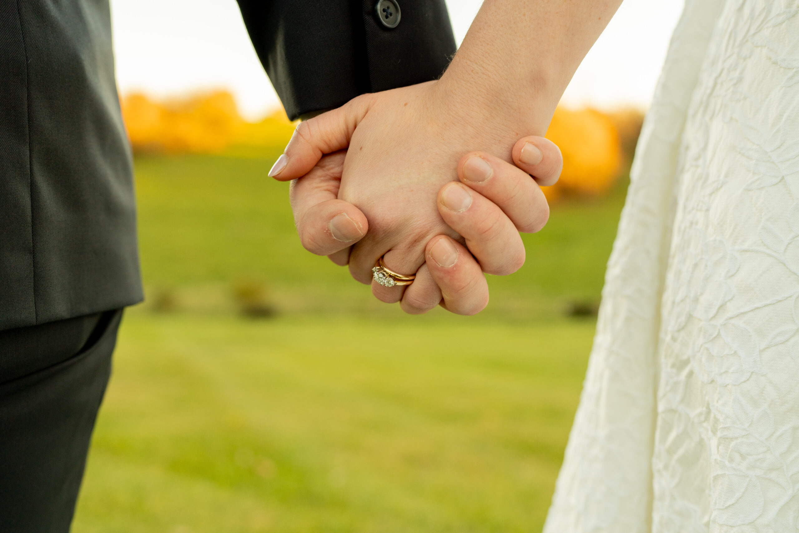 Couple holding hands in golden field at Batten Green wedding in Virginia.