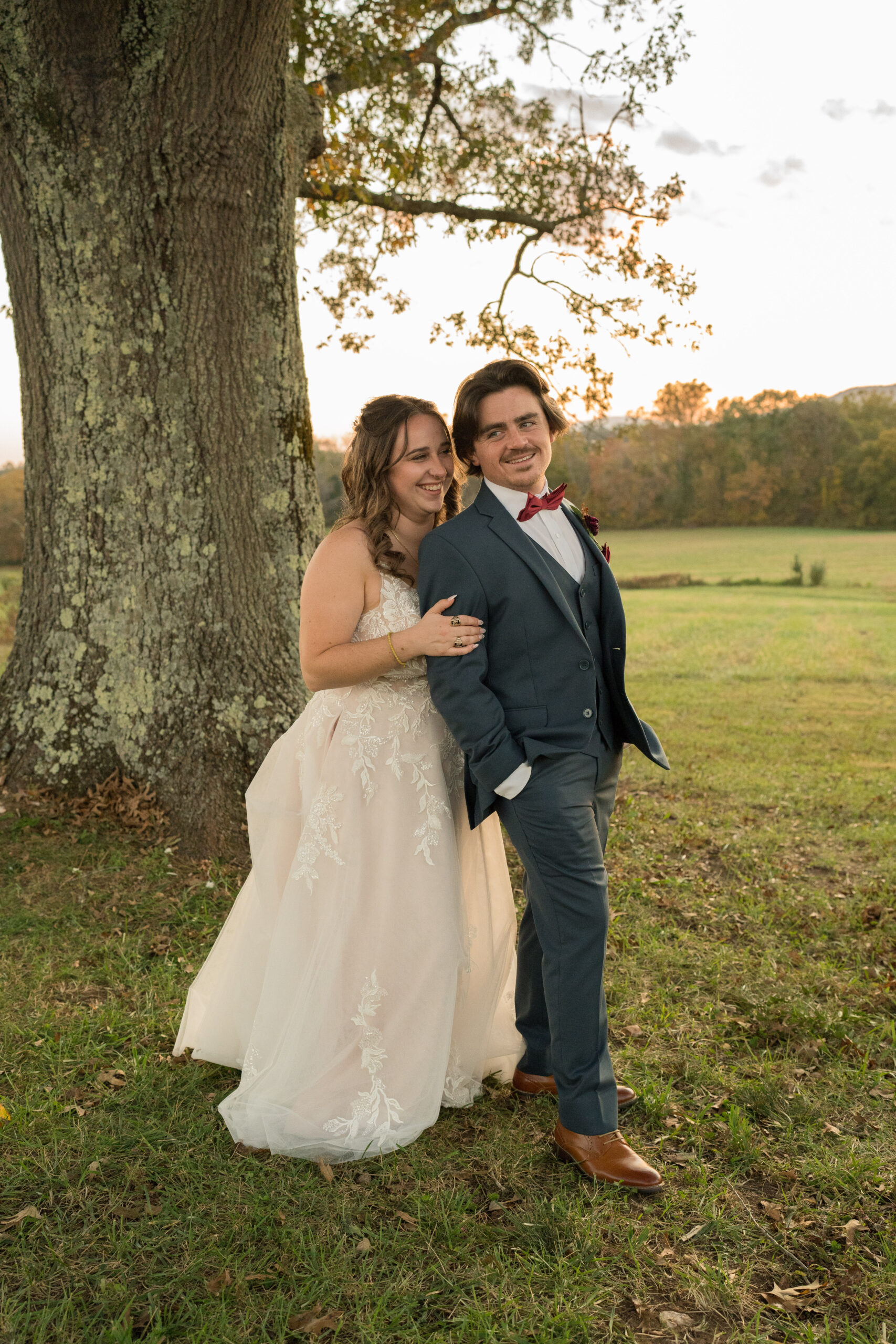 Bride and groom standing under a tree at sunset during their fall elopement at The Barn at Edgewood in Stanardsville, Virginia.