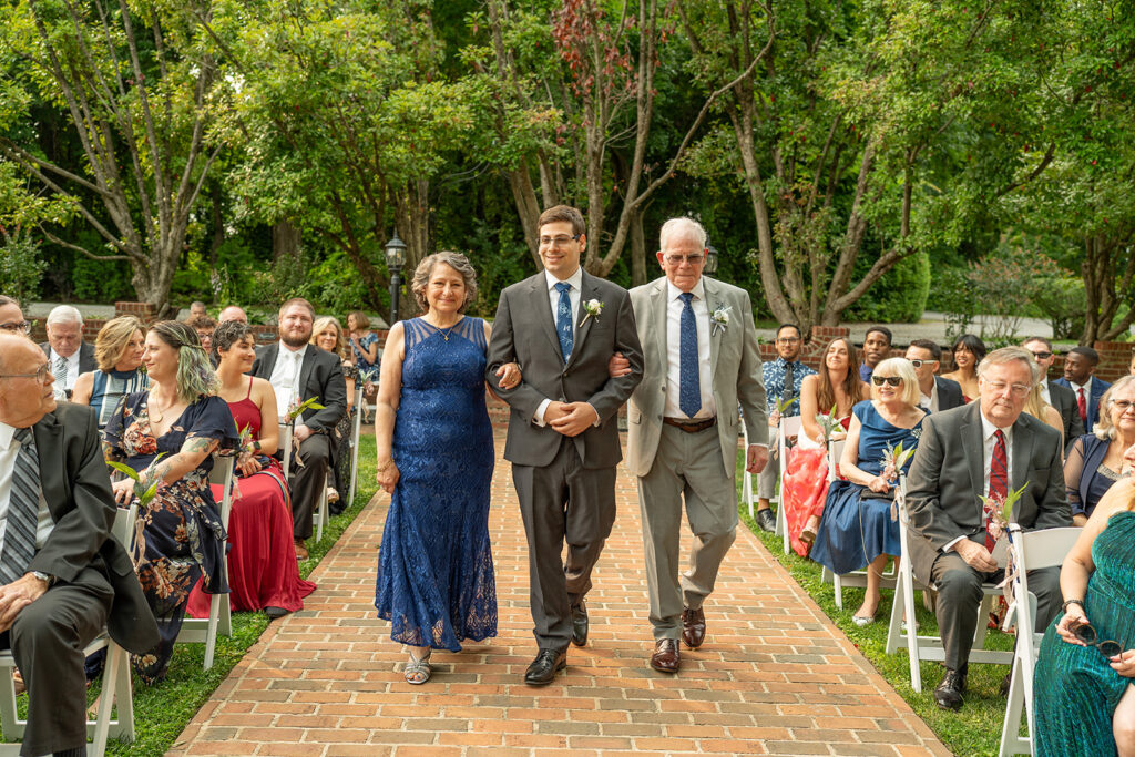 Groom walking down the aisle with parents at Mankin Mansion outdoor garden ceremony, Richmond VA
