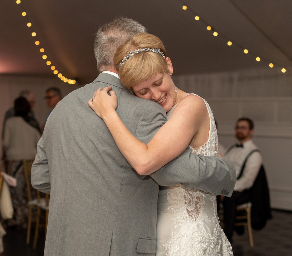 Bride hugging her father during a dance at Mankin Mansion wedding reception under string lights, Richmond VA